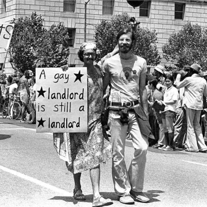 The meme features a photograph of a 1970s gay rights protest, with a sign being held by a protester that reads "A gay is a boy or girl who doesn't like boys or girls" in response to a sign that reads "A gay is a boy or girl who likes boys or girls."
